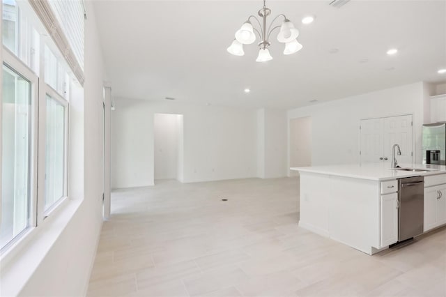 kitchen featuring pendant lighting, an inviting chandelier, dishwasher, white cabinets, and an island with sink