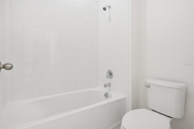 bathroom featuring tiled shower / bath combo and toilet