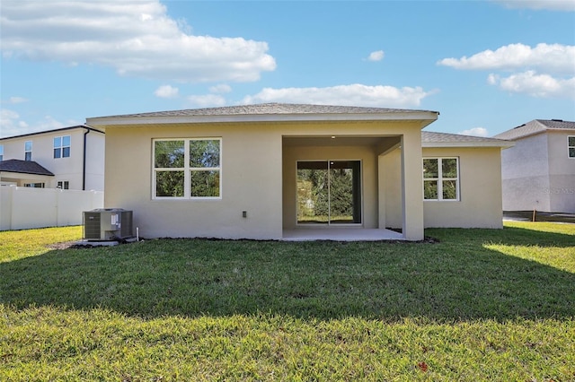 rear view of property with a lawn, a patio area, and central air condition unit