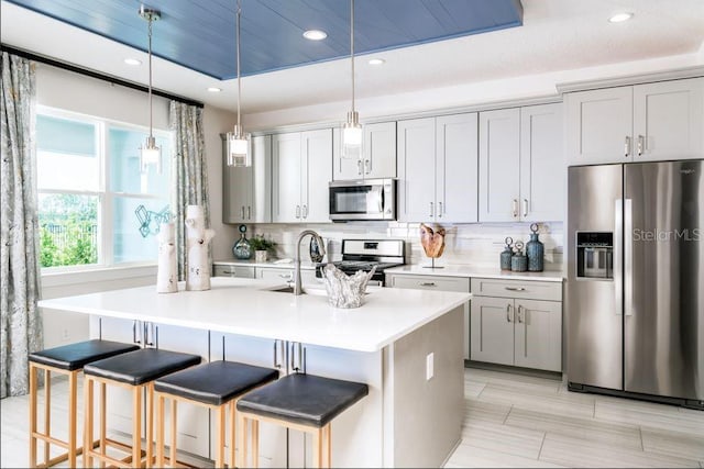 2424 Park Ridge St, Apopka, FL 32712 - kitchen featuring appliances with stainless steel finishes, a kitchen bar, light countertops, tasteful backsplash, and recessed lighting