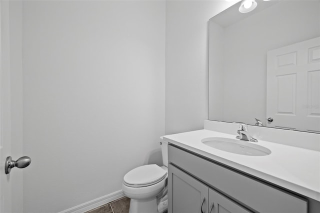 bathroom featuring toilet, vanity, and baseboards