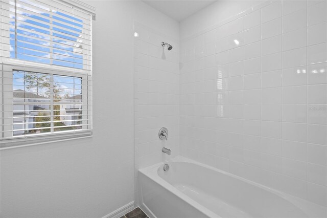 bathroom with shower / bath combination and baseboards