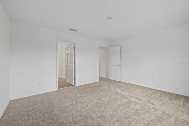 carpeted spare room featuring baseboards