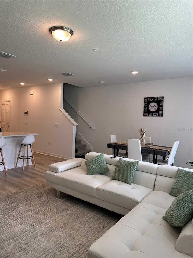 living room featuring a textured ceiling and wood-type flooring