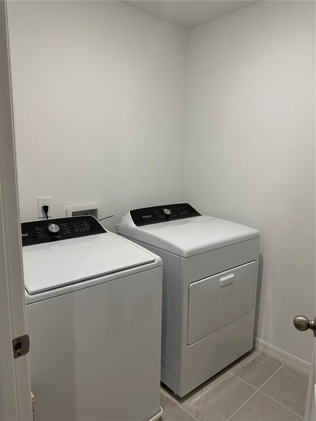 laundry room featuring light tile patterned floors and independent washer and dryer