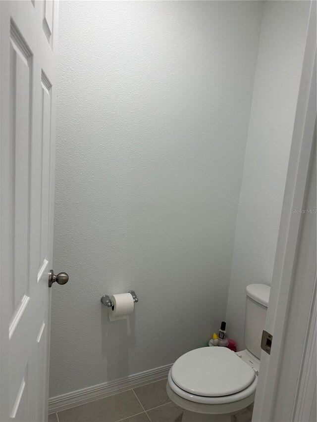 bathroom with toilet and tile patterned flooring