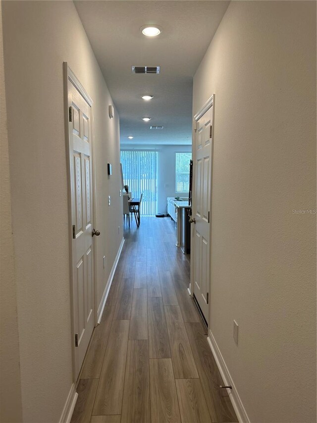 hallway with hardwood / wood-style flooring