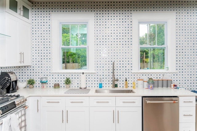 kitchen with stainless steel appliances, white cabinetry, plenty of natural light, and sink