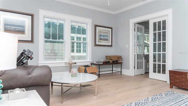 sitting room with ornamental molding, french doors, and light wood-type flooring