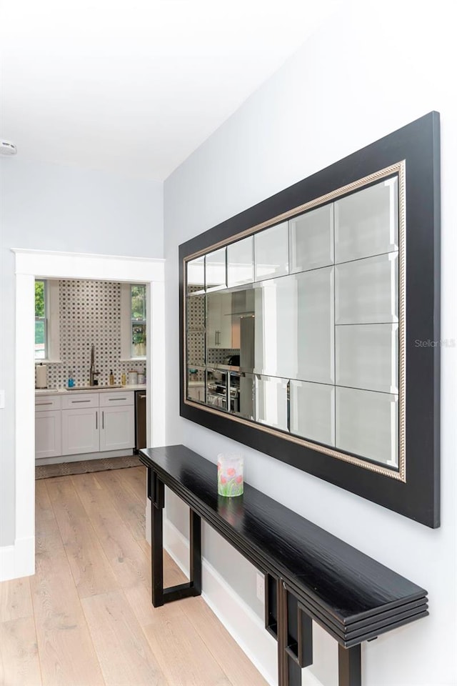 hallway with sink and light hardwood / wood-style flooring