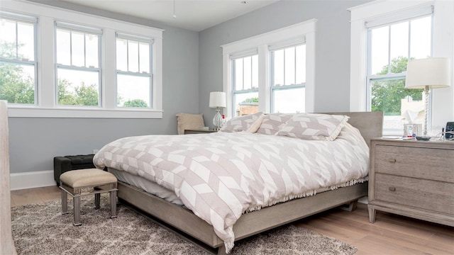 bedroom featuring multiple windows and light wood-type flooring