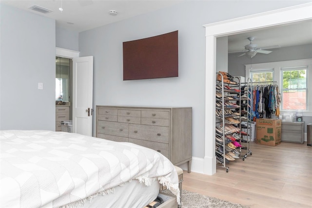 bedroom with ceiling fan, a closet, light hardwood / wood-style flooring, and a walk in closet