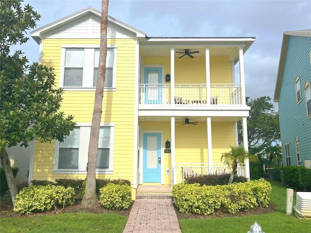 view of front of property with ceiling fan, a front lawn, and covered porch