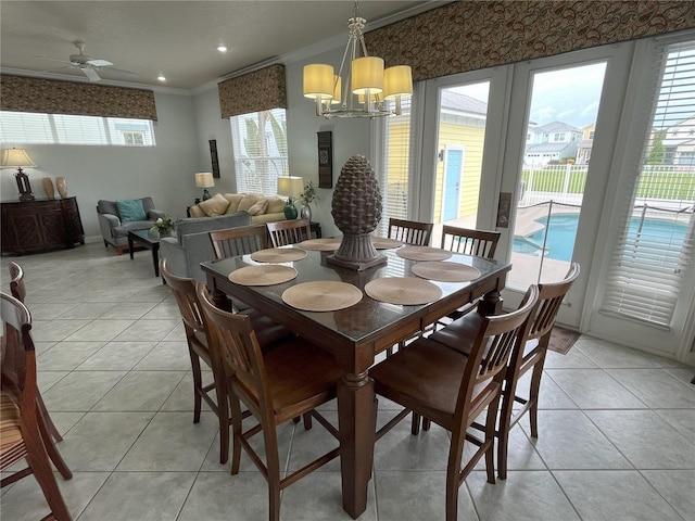 tiled dining space with ornamental molding, a wealth of natural light, and ceiling fan with notable chandelier