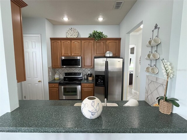 kitchen with stainless steel appliances and tasteful backsplash