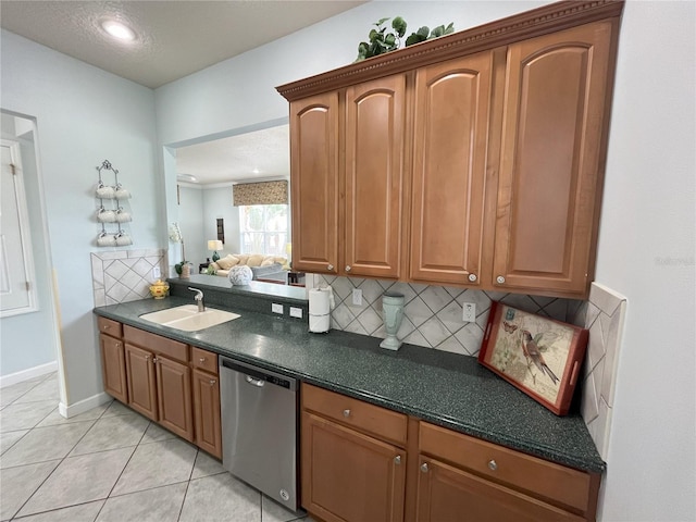 kitchen featuring decorative backsplash, stainless steel dishwasher, sink, light tile patterned floors, and a textured ceiling