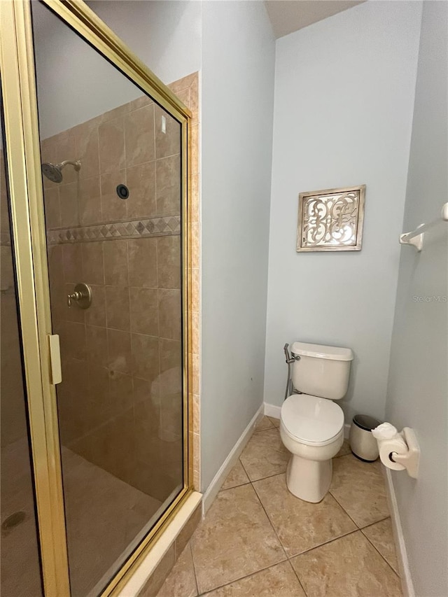 bathroom featuring tile patterned flooring, an enclosed shower, and toilet