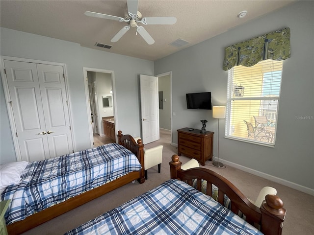 bedroom with ensuite bathroom, ceiling fan, carpet floors, and a closet