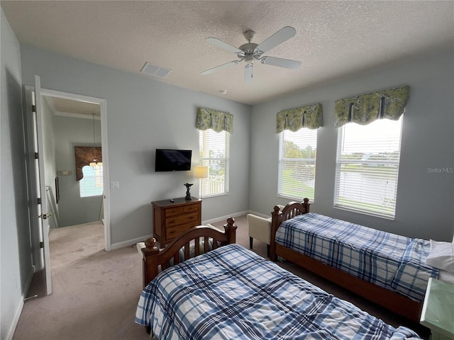 carpeted bedroom featuring ceiling fan and a textured ceiling