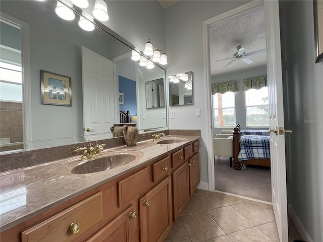 bathroom with tile patterned flooring, ceiling fan, vanity, and a textured ceiling