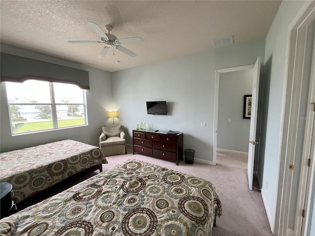 carpeted bedroom featuring a textured ceiling and ceiling fan