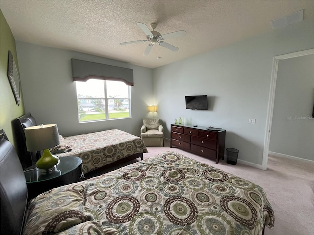 carpeted bedroom with a textured ceiling and ceiling fan