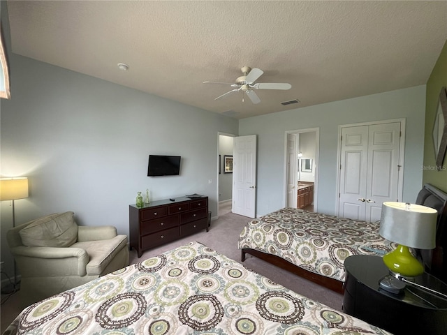 bedroom featuring ceiling fan, a closet, light carpet, ensuite bathroom, and a textured ceiling