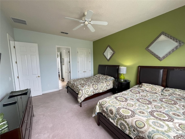 carpeted bedroom with a closet, a textured ceiling, and ceiling fan