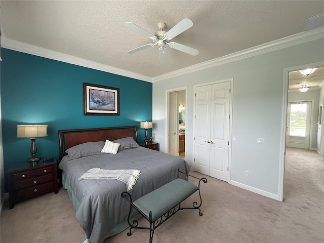 carpeted bedroom featuring crown molding, ensuite bathroom, a textured ceiling, and ceiling fan