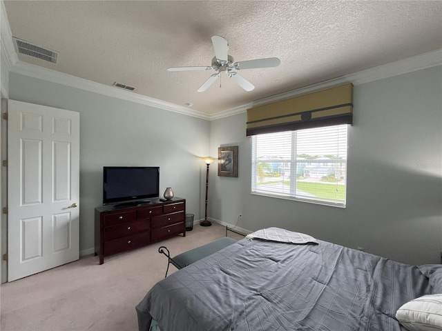 bedroom with a textured ceiling, ceiling fan, ornamental molding, and light colored carpet