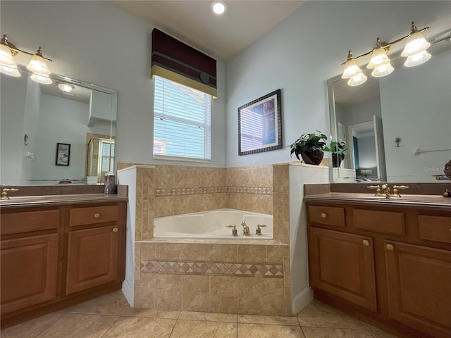 bathroom featuring tile patterned floors, tiled tub, and vanity