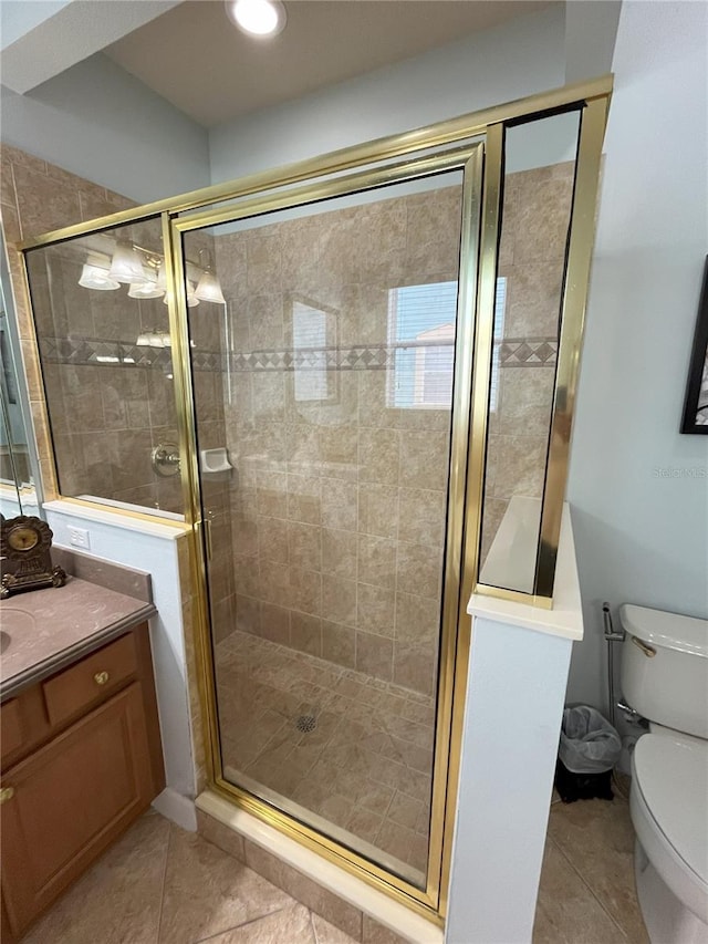 bathroom featuring tile patterned flooring, vanity, walk in shower, and toilet