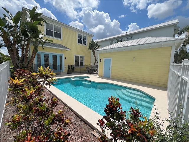 rear view of property featuring a standing seam roof, a fenced backyard, an outdoor pool, and a patio