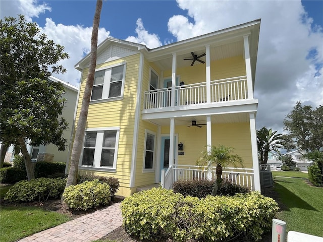 view of front facade featuring a porch, a front yard, a balcony, and ceiling fan