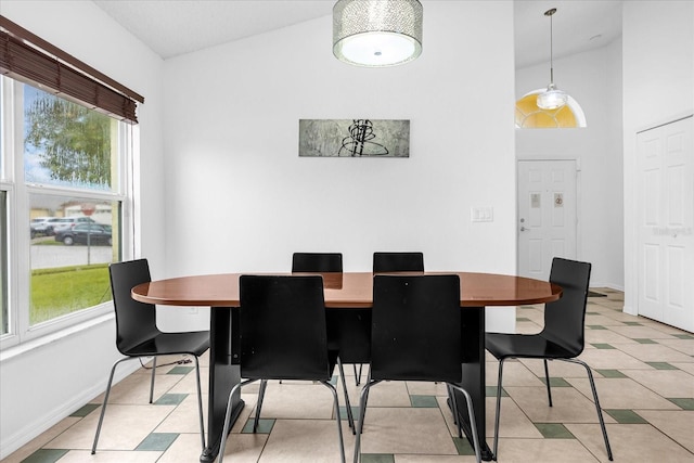 tiled dining area with high vaulted ceiling and plenty of natural light