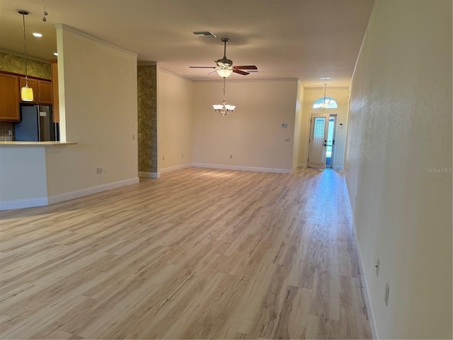 unfurnished living room with ceiling fan with notable chandelier, light hardwood / wood-style floors, and ornamental molding