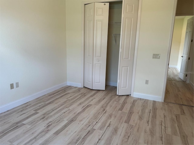 unfurnished bedroom featuring light hardwood / wood-style flooring and a closet