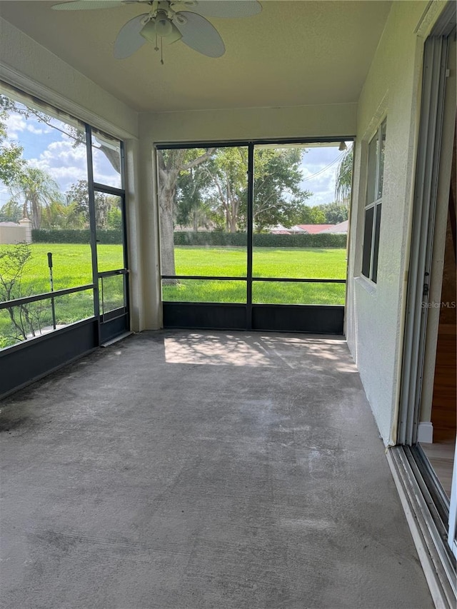 unfurnished sunroom with ceiling fan