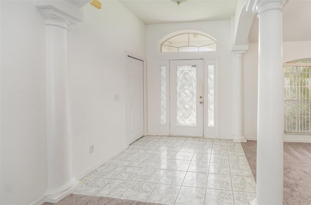 tiled entrance foyer with ornate columns and a wealth of natural light