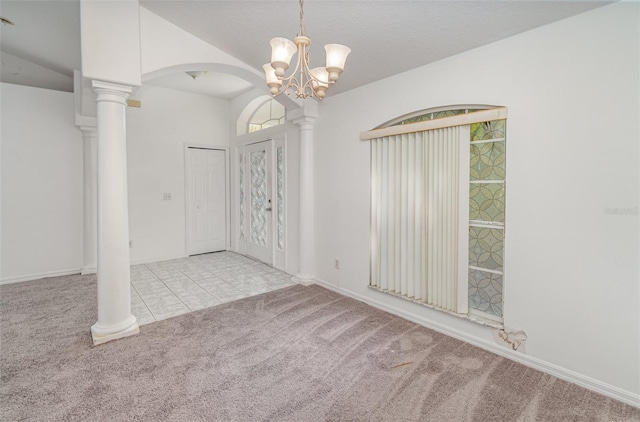 empty room with lofted ceiling, decorative columns, light carpet, and a chandelier