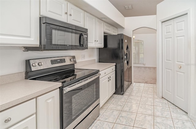 kitchen featuring light carpet, black appliances, and white cabinetry