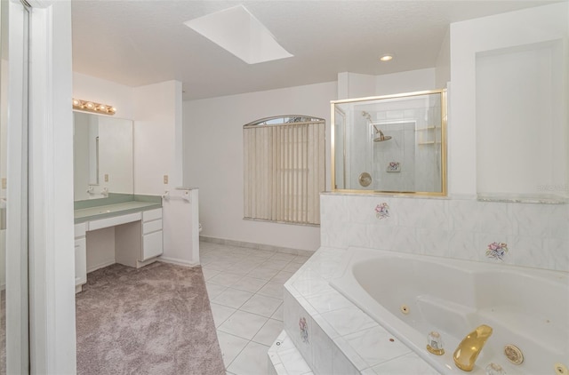 bathroom with a skylight, plus walk in shower, vanity, and tile patterned flooring