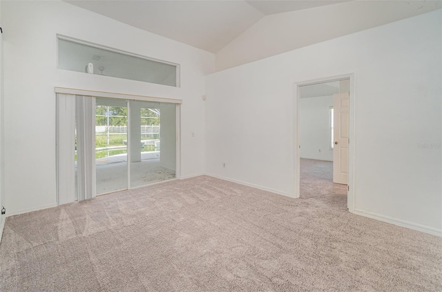 carpeted empty room featuring lofted ceiling