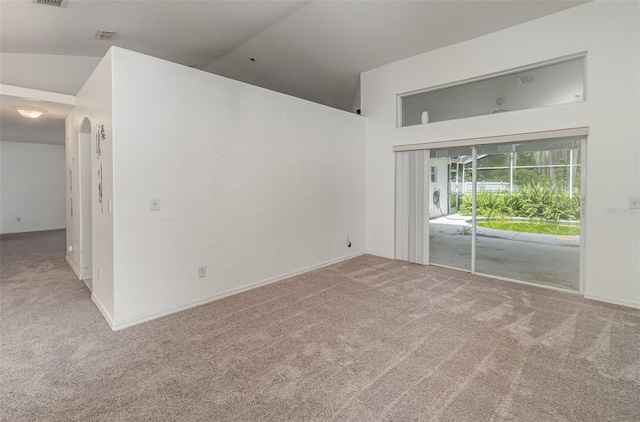 spare room with carpet and lofted ceiling