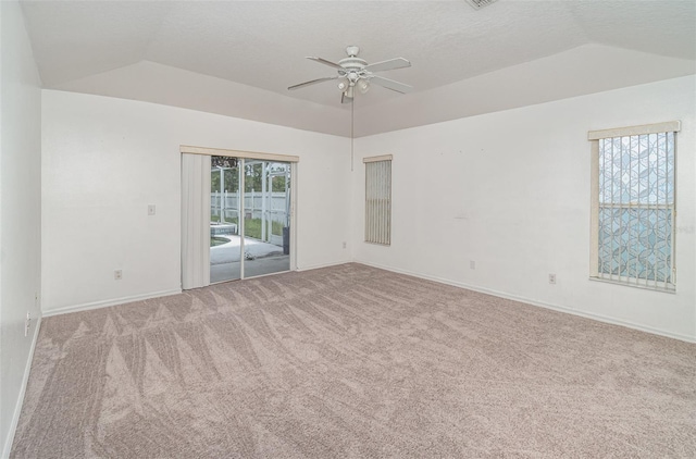 carpeted spare room with ceiling fan and vaulted ceiling