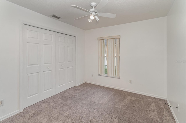 unfurnished bedroom featuring ceiling fan, a closet, and carpet