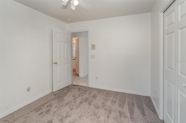 unfurnished bedroom featuring ceiling fan, light carpet, and a closet