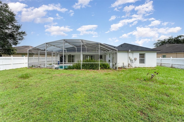 back of property with glass enclosure, a fenced in pool, and a yard