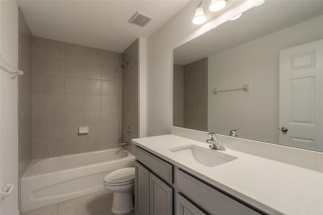 full bathroom with vanity, tiled shower / bath combo, toilet, and tile patterned flooring