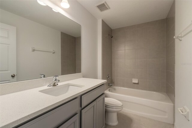 full bathroom featuring tiled shower / bath combo, toilet, and vanity